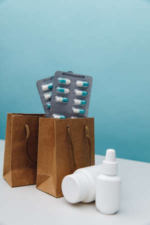 Bags with pills and medical white containers close-up, online shopping theme. Vertical imageの写真素材