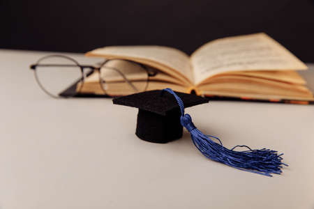 Graduation cap and glasses with open book. Education and science conceptの写真素材