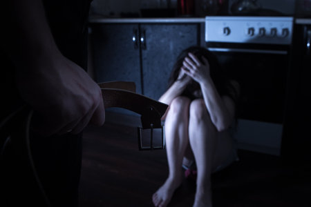Unhappy wife trying to escape from domestic violence and her husband wants to hit herの写真素材