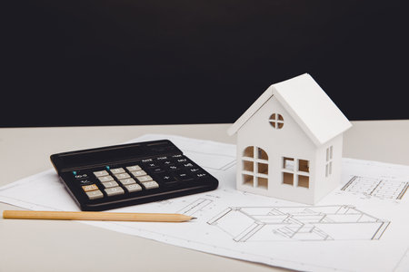 Model of house and calculator on architectural project. House building costs conceptの写真素材