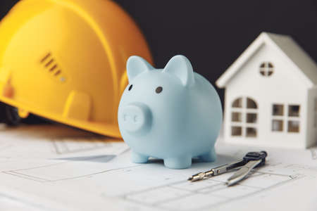 Construction safety helmet, house and blue piggy bank. Building and business conceptの写真素材