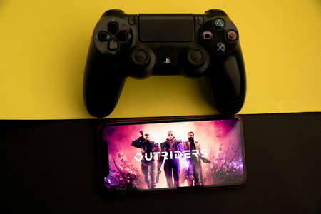 Tula, Russia - April 08, 2021: Outriders preview on iPhone display and PS gamepadのeditorial素材