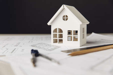 Building theme. Blueprint with white house, drawing tools and glasses on a table close-upの写真素材