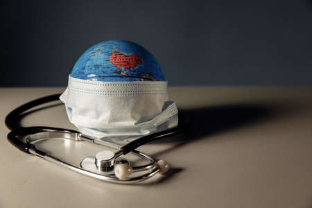 Globe with medical mask and stethoscope. International healthcare conceptの写真素材