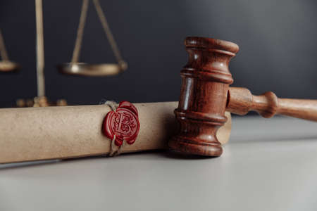 Gavel and document with wax seal on a lawyers desk close-upの写真素材