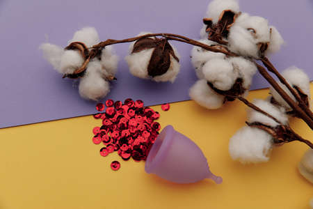 Hygienic menstrual cup with red shining sequins and cotton. Alternative way of feminine hygieneの写真素材