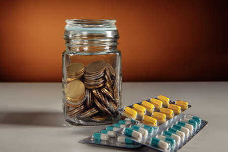 Health insurance, coin money jar with pillsの写真素材
