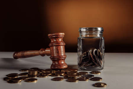Coins in a glass jar and gavel