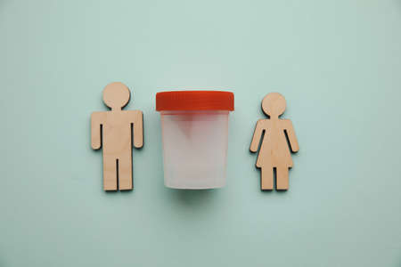 A plastic jar with sperm and wooden couple on a table. Pregnancy, healt care and analysis conceptの写真素材