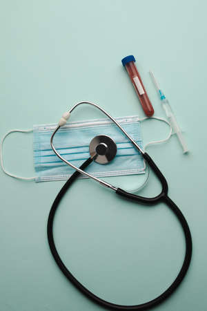 Top view stethoscope, test tube with blood samples and syringe isolated on blue background. Vertical imageの写真素材
