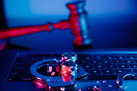 Handcuffs, gavel and chips on a laptop. Online casino conceptの写真素材