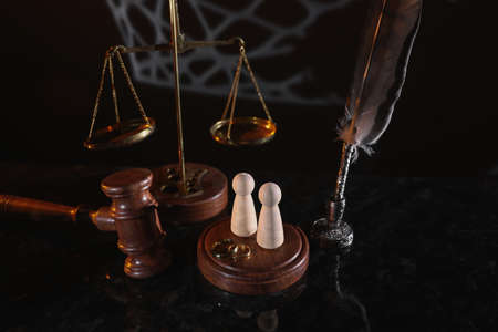 Law and Justice. Vertical image of judge gavel, wooden figures and wedding rings