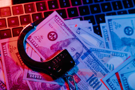 Handcuffs and dollar banknotes. Financial risk, debt default conceptの写真素材