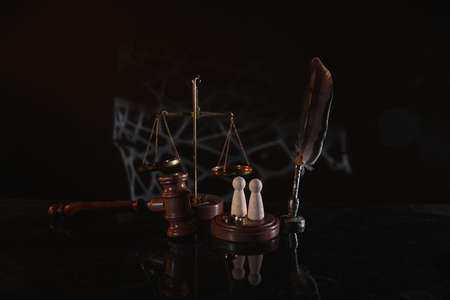 Law and Justice. Vertical image of judge gavel, wooden figures and wedding ringsの写真素材