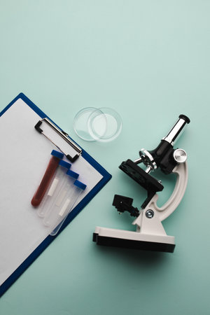 Microscope, test tubes and watch glass on a blue background. Laboratory or analysis theme. Vertical imageの写真素材