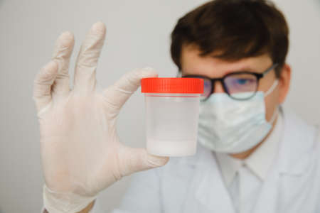 The doctor looks at the pills in a plastic cup in his hand. Medacine, Pills, medicine, vitamins conceptの写真素材