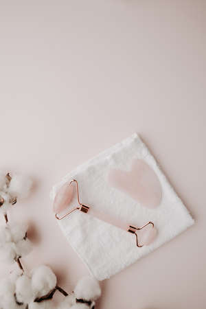 Skin care concept. Massage tools for face therapy with towel on a pink background. Vertical imageの写真素材