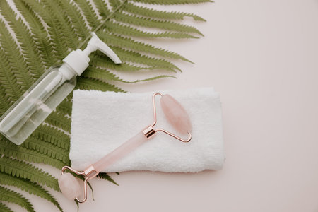 Jade face roller with towel on a fern leaf. facecare concept.の写真素材