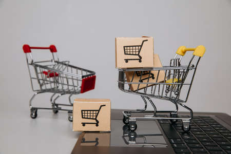 Sales theme. Trolley with paper boxes on a keyboardの写真素材