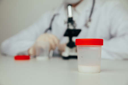 A plastic jar with sperm for semen analysis. Medical test in hospitalの写真素材