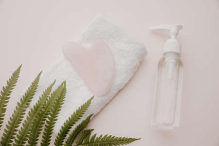 Beauty product with gua sha on a towel and fern. Scin care conceptの写真素材