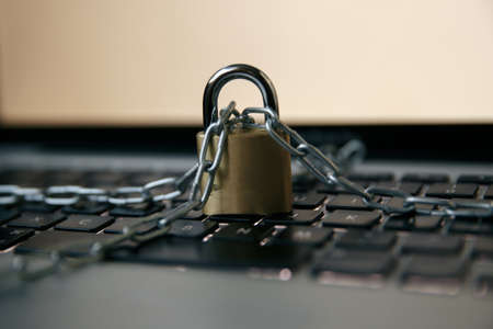 The concept of cybersecurity is locked and the key on the laptop keyboard, the key to unlock front of a white background.Key and lock. Laptop lockの写真素材