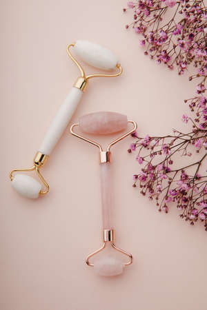 Face rollers made from natural jade stone on a pink background. Vertical imageの写真素材