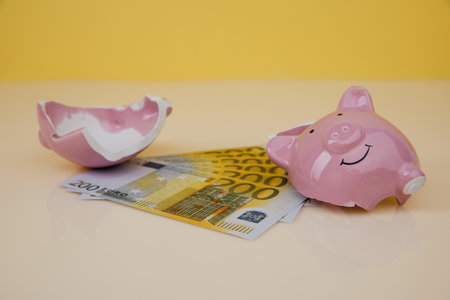 Investment and savings concept. Broken piggy bank with euro banknotes on a tableの写真素材