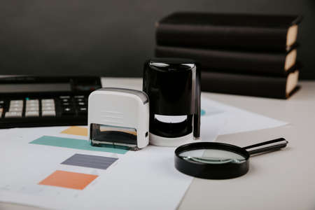 Concept of signing a contract and approvement. Office desktop with documents and stampの写真素材