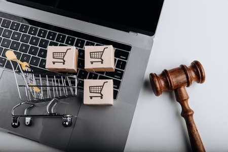 Judge gavel and shopping cart with card boxes on a laptop. Sanctions conceptの写真素材