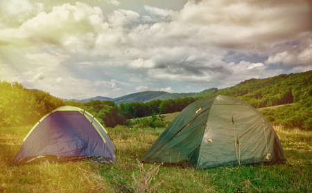 Tourist tent in forest camp among meadowの写真素材