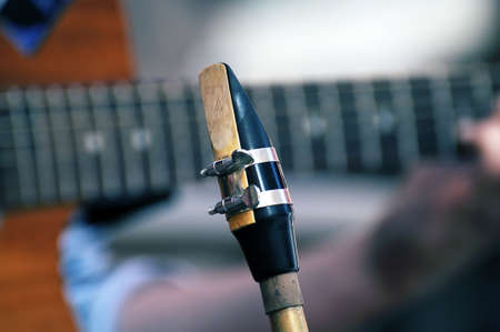 Saxophone mouthpiece on a background of classical guitar