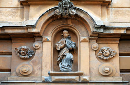 An ancient statue in the wall of the house.