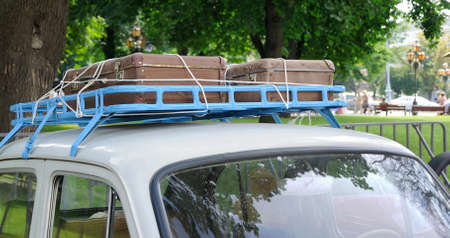 Classic old car with vintage worn suitcases on roofの写真素材