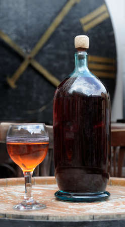 Wine in old bottles on a barrel.の写真素材