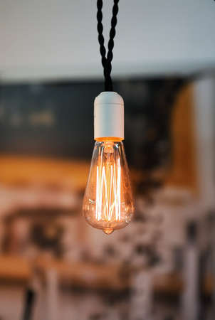 Old dusty light bulb glowing in the dark