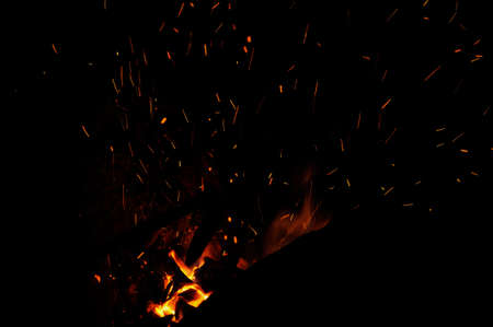 Smithy fire flame tips with sparks closeup on dark background