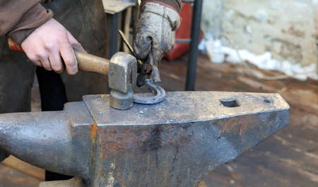 Blacksmith forges a horseshoe for horse