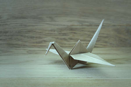 Origami crane on a wooden  background close-upの写真素材