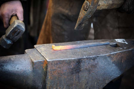 Blacksmith forges a horseshoe in a smithy