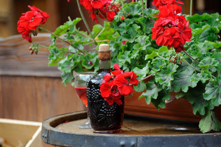 Wine in old bottles into a barrel decorated with flowersの写真素材