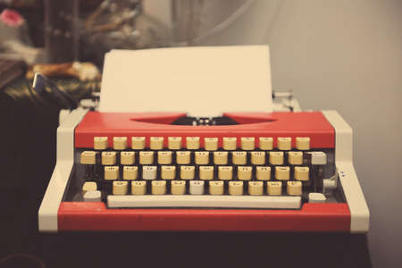 Red typewriter with paper sheet on wooden tableの写真素材