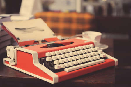 Red typewriter with paper sheet on wooden tableの写真素材
