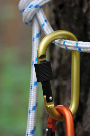 Carabiner with rope on nature background. Climbing uquipment.Climbing sports image of a carabiner on a rope.の写真素材