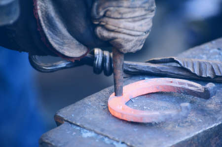 The blacksmith kicks a horseshoe close up .の写真素材