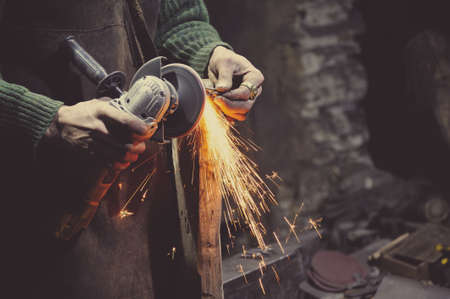 The master treats the workpiece with a grinding machineの写真素材