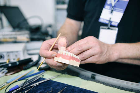 Dental technician manifacturing medical tooth prosthetic in laboratoryの写真素材