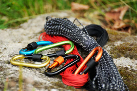 Metal carabine and rope for mountaineering. Photo of colored carabines and rope. Climbing concept