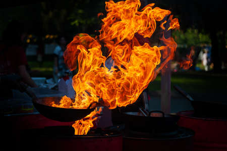 Cooking street food on a hot frying pan. Street food festival