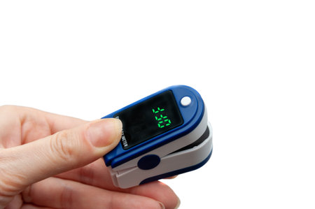 Pulse oximeter used to measure pulse rate and oxygen levels. Close up of Finger in an Oximeter Device. Pulse oximeter on white background.の写真素材